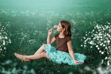 A 10-year-old girl walks in a field with white flowers. The girl is holding a bouquet. The girl is...