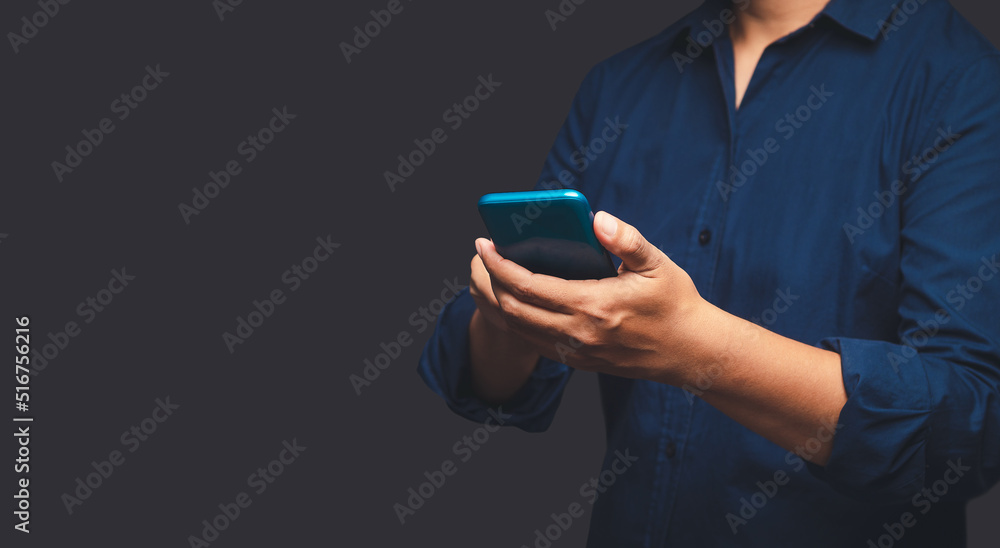 Poster close-up of hands businessman in a suit using a mobile phone while standing on a gray background.