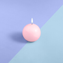 Obraz na płótnie Canvas A pink round candle on a blue and purple background. Minimal concept. Square isometric layout with copy space.