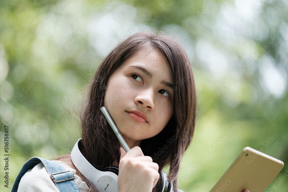 Fototapete Young Asian teenage girl with tablet and notebook