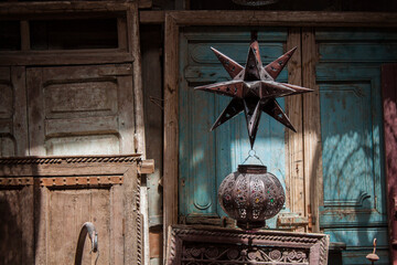 Traditional metal lanterns and pieces of wooden furniture with authentic patterns in the historical Souk market in the downtown (old Medina) of Marrakesh, Morocco, Africa.