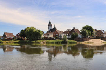 Fototapeta na wymiar Blick über die Weser auf Lüchtringen mit Pfarrkirche St. Johannes Baptist