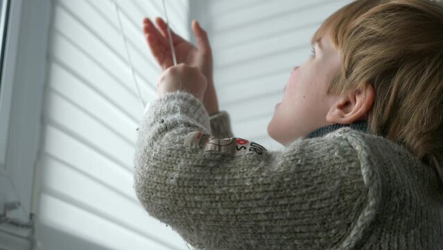Little Boy Kid Opens Window Roller Shutter Blinds Curtain. Cute Child at Home. 2x Slow motion 60 fps 4K