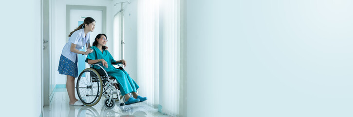 Fototapeta premium asian young Doctor caring for her elderly patient at senior daycare,cheerful nurse wheeling Senior patient concept.Asian elderly patient in wheelchair at hospital looking out window with new hope