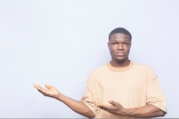 good looking african man holding up hands to opposite direction carrying invisible items