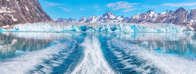 Waves of blue sea behind the speedboat water - Background water surface behind of fast moving motor boat across the     Knud Rasmussen Glacier near Kulusuk - Greenland, East Greenland  - obrazy, fototapety, plakaty