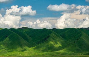 clouds shadow on green mountains