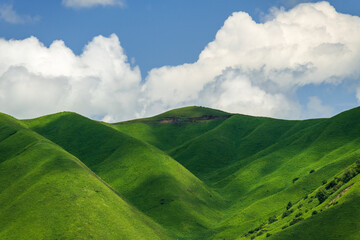 clouds shadow on green mountains