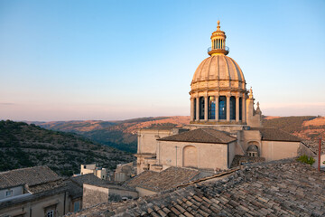 Dome of church under the town and mountains behind it.