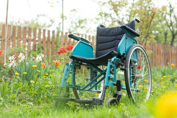 Fototapeta na wymiar old wheelchair in the garden.