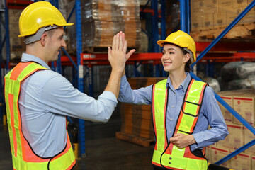 Happy smiling teamwork with hardhats and reflective jackets give high five celebrate successful together completed deal commitment at retail warehouse logistics, distribution center, success concept