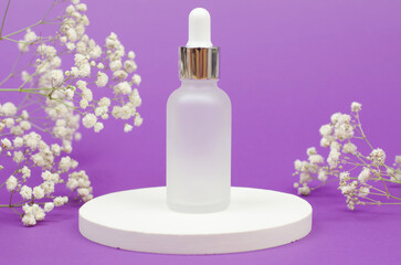 Cosmetic bottle with a dropper on a white podium with a bouquet of gypsophila. Skin care cosmetics