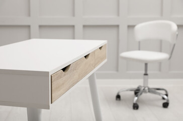 Modern white table with office chair indoors, closeup. Space for text