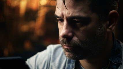 Close up shot of a middle-aged craftsman with smartphone resting in his equipped garage after metal processing and grinding for barbecue grill