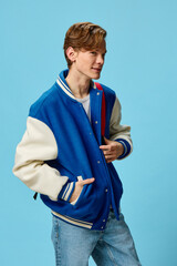 a handsome happy guy student in a fashionable bomber jacket and with a backpack on his shoulder...