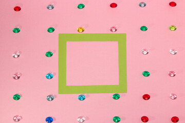 green frame as copy space on pink background, creative art modern design, fake gemstone rain