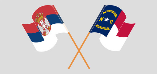 Crossed and waving flags of Serbia and The State of North Carolina