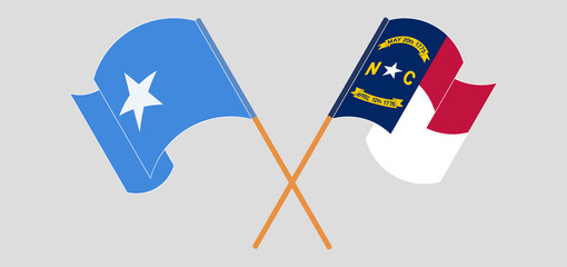 Crossed and waving flags of Somalia and The State of North Carolina