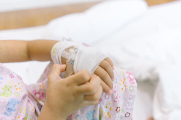 Close up kid hand with saline intravenous at hospital