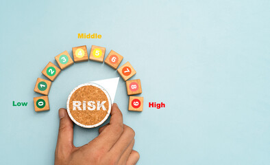 Investor hand turning risk button from low to high position for risk management survey and analysis  of business investment concept.