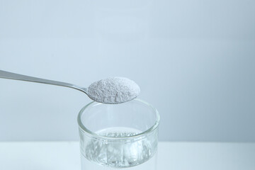 Biological food supplement. Dietary supplement for healthy sleep. Glass, spoon and dietary supplement powder. Modern still life. 