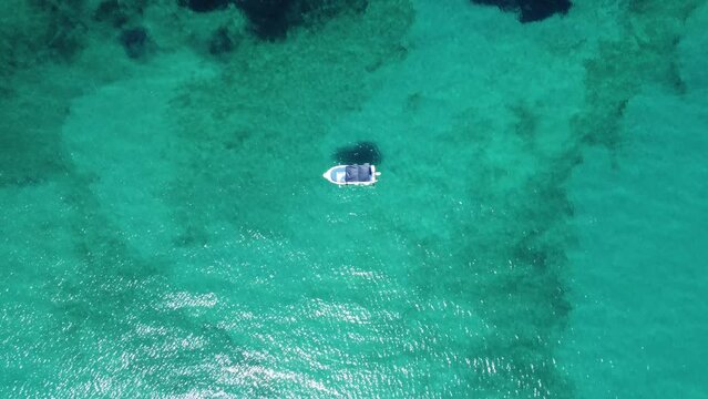 Top view of a lonely boat in a paradisiac sea - travelling out