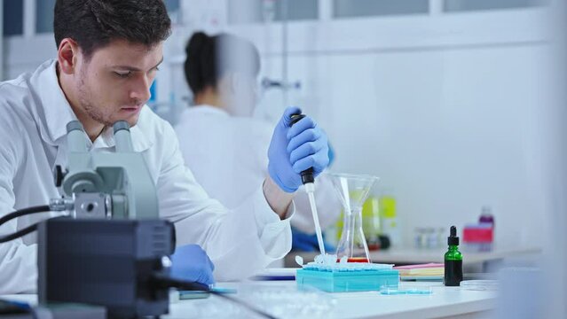 Cosmetology lab scientist studying characteristics of plant extract, experiment