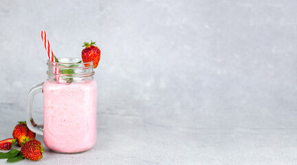 Strawberry milkshake in glass jars with fresh strawberries. Banner with place for text