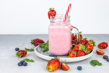 Strawberry milkshake. Cocktail glass on a platter with strawberries.