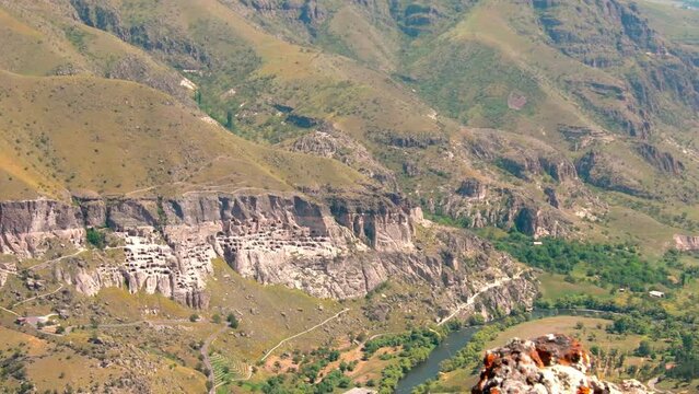 Aerial view Mtkvari canyon Vardzia-cave city from above with paravani river and autumn nature in foreground. Historical unesco sites Georgia.