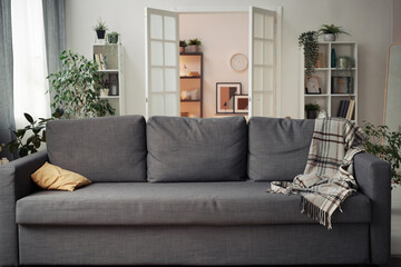 Horizontal image of comfortable big sofa standing in living room in apartment