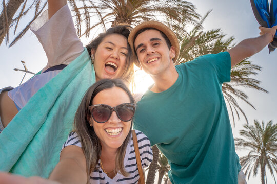 Selfie of multiracial group of friends happy laughing in the beach in summer.