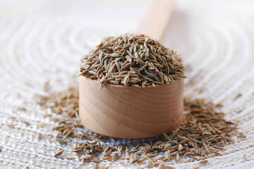 cumin seeds on spoon on table , close up 