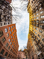 Looking up at a vertical view of a block of old buildings in New York City with fisheye lens effect