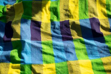 Green plaid on beach. Bedspread at picnic. Tablecloth for eating. Blanket for relaxation.