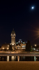 Fototapeta na wymiar Limoges train station at night with moon, France, vertical picture