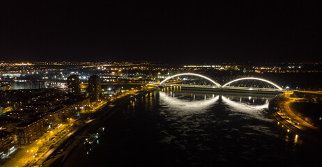 The capital of Vojvodina, Novi sad at night. The bridge on the Danube river. Aerial photography.