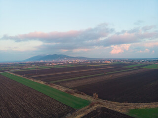 The town of Vr&scaron;ac with fields, hills behind and clouds in the sky. Aerial photo.