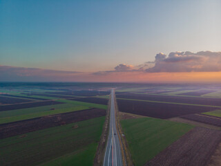Straight road through the fields. Aerial photo.
