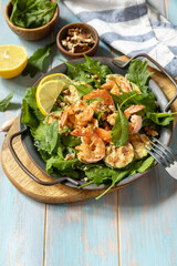 Healthy food concept. Diet summer salad plate. Shrimps salad with arugula, grilled zucchini and walnut. Copy space.