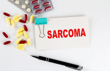SARCOMA text written in a card with pills. Medical concept.