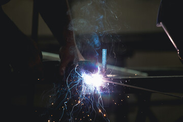 Fototapeta na wymiar Industry worker welding iron pieces at work