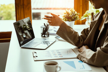 Young beautiful Asian woman working with a laptop while sitting at office desk, working from home concept.