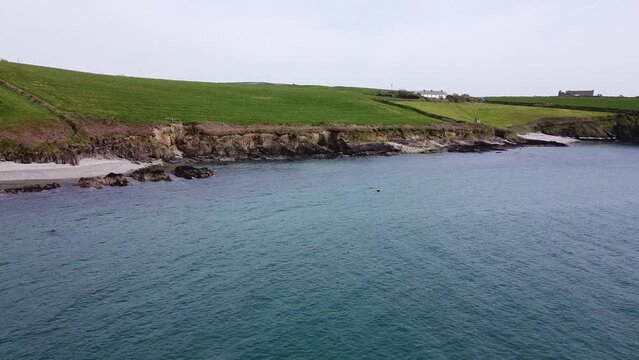The hilly shores of the south of Ireland. The waters of the Celtic Sea.