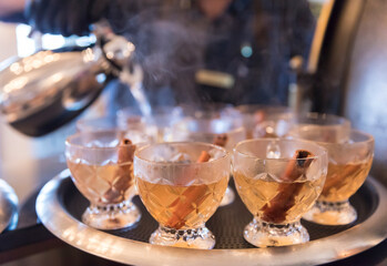 A tray of hot toddies being poured with steam rising