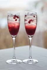Two cranberry and pomegranate cocktails in champagne glasses