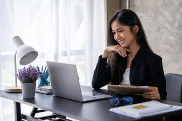 Asian woman working on a laptop computer,Working in the office with laptop concept,Young Asian woman starting a business using a laptop computer.