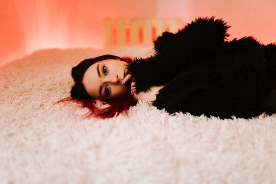 Portrait Of Beautiful Woman Lying On Bed