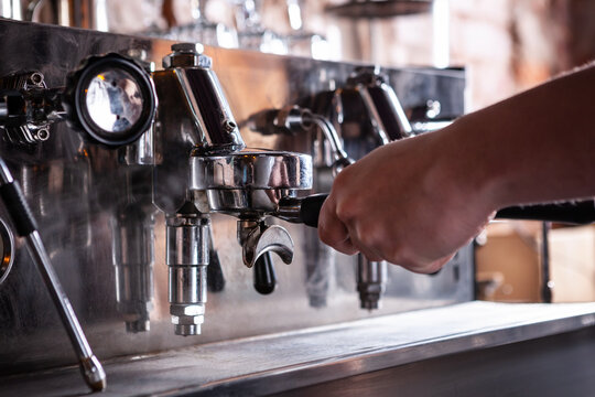 Close up of barista warming up espresso coffee machine.