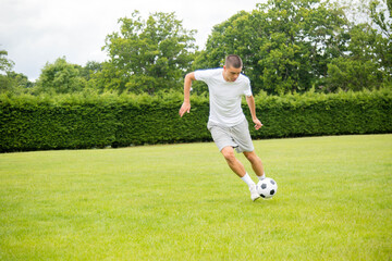 A Nineteen Year Old Teenage Boy Playing Football in A Public Park